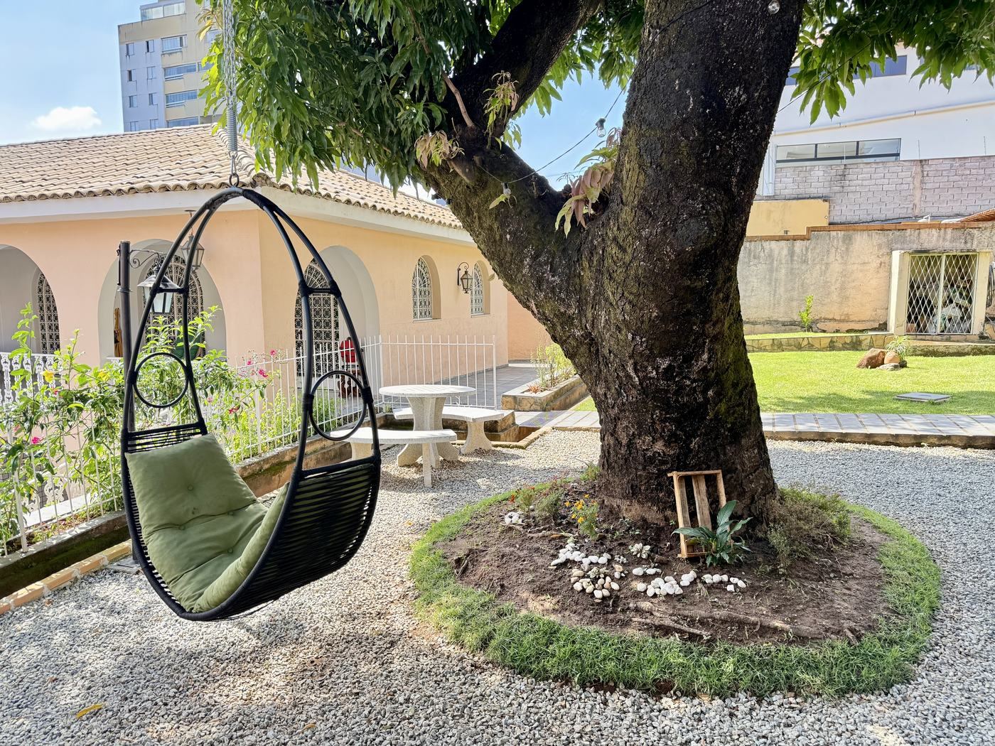 Balanço suspenso à sombra da árvore no jardim do Casarão José Morada