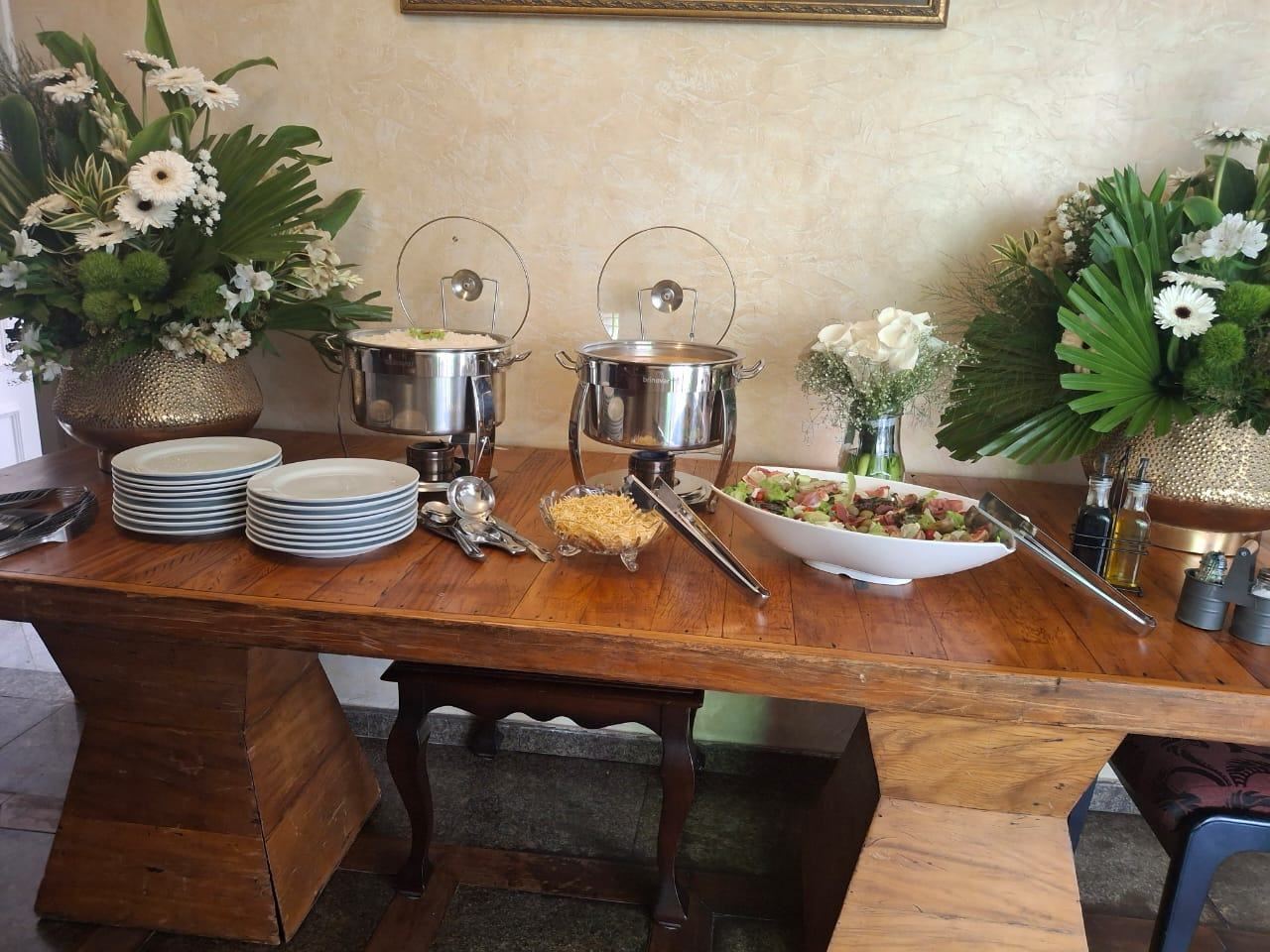 Buffet montado sobre mesa de madeira para evento no Casarão José Morada